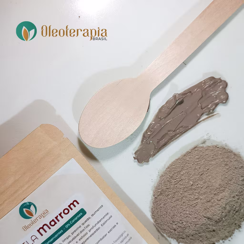 A imagem mostra uma parte da embalagem da argila marrom, uma colher de madeira, e uma amostra da argila já úmida e uma porção da argila em pó.