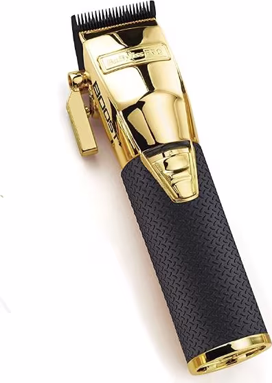 Máquina de corte de cabelo BaByliss Pro. Corpo preto texturizado com detalhes dourados. Lâminas de corte expostas na parte superior em metal dourado. Design ergonômico com empunhadura antiderrapante. Aparência robusta e durável.