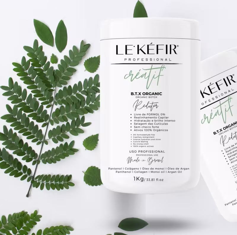 Em destaque na imagem estão duas embalagens do produto. As embalagens brancas apresentam o nome do produto em verde, junto com alguns benefícios listados. Ao redor, há galhos com folhas verdes, complementando a temática natural e orgânica dos produtos.