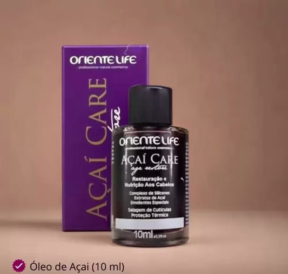 A imagem mostra a caixa do produto, toda roxa com palavras escritas em preto e dourado, além do produto mais a frente.
