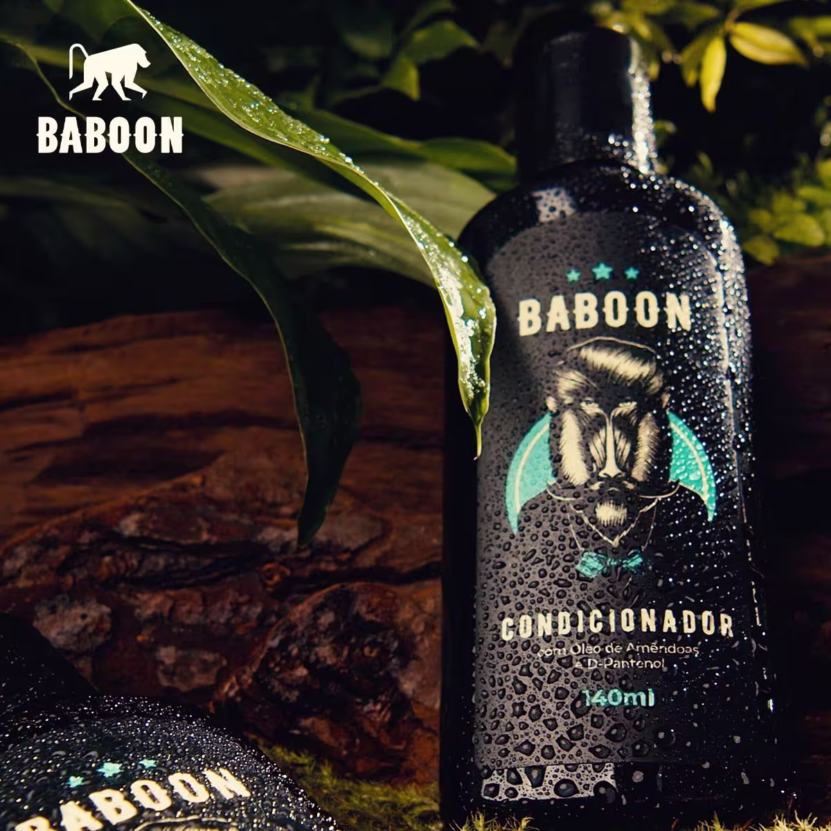 Condicionador Baboon em frasco preto de 140ml. O frasco tem detalhes brilhantes e estampado com a imagem de um babuíno e estrelas turquesas. Há gotas de água escorrendo pelo frasco.