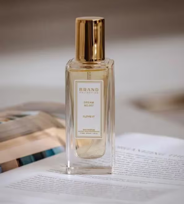 A imagem apresenta o frasco do perfume em cima de uma revista aberta.