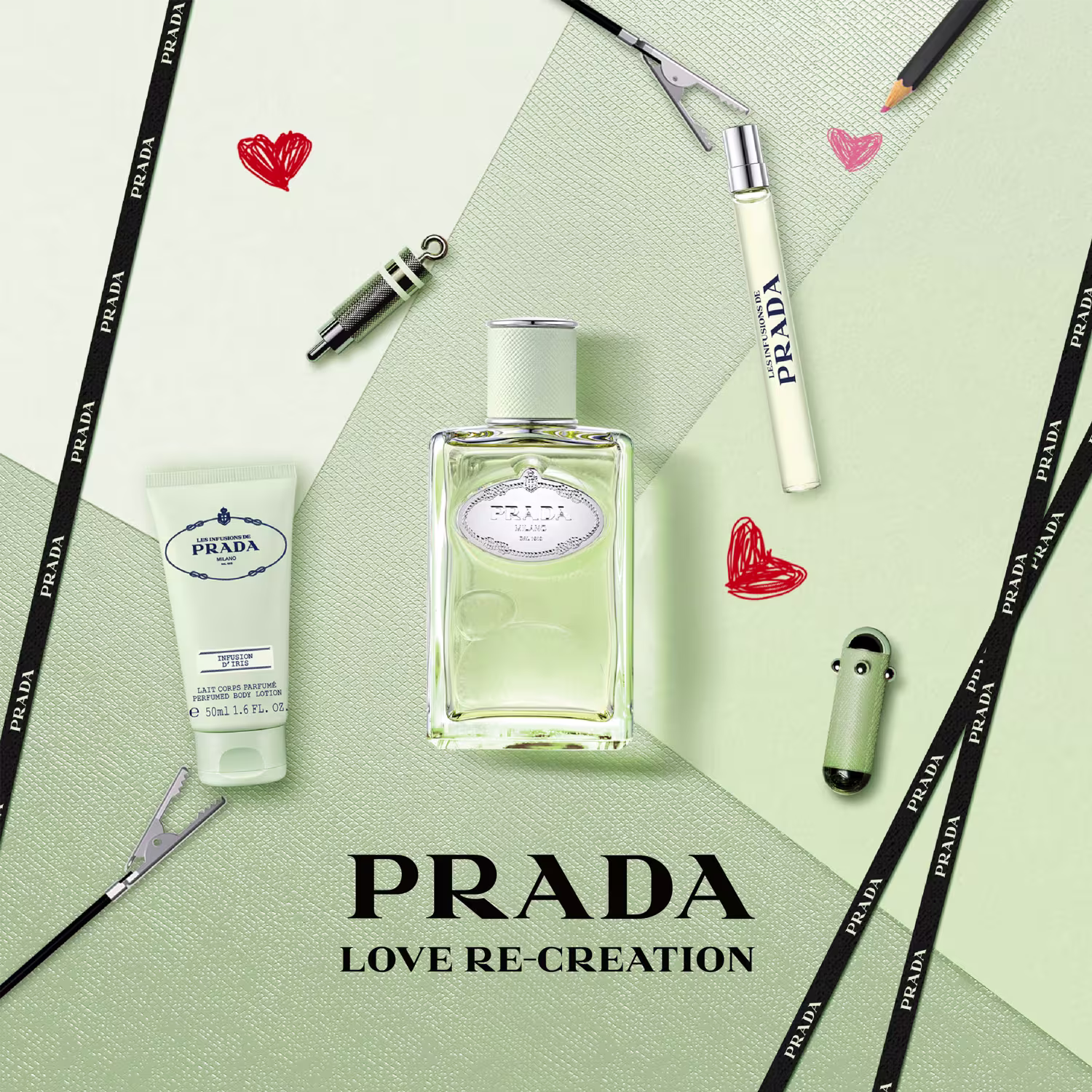 Composição de objetos: ao centro, perfume em frasco retangular transparente com rótulo "Prada" e "Love Re-Creation". Lápis de maquiagem, batons vermelho e rosa, pincel de maquiagem e creme corporal com logo Prada. Corações vermelhos desenhados ao redor.