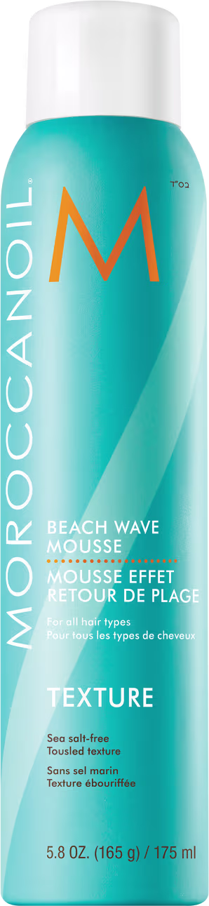 Frasco de mousse Moroccanoil Beach Wave, com embalagem azul turquesa e laranja, rótulo com nome da marca e descrição "Mousse Efeito Retour de Plage" para todos os tipos de cabelo.