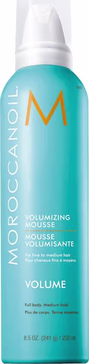 A imagem mostra o produto Moroccanoil Volume Volumizing Mousse 250ml, em embalagem azul claro com logotipo M em laranja. Indicado para cabelos finos a médios.