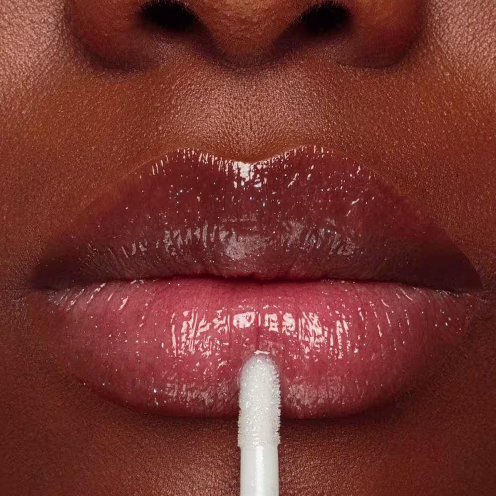 Gloss aplicado em lábios de pele negra.