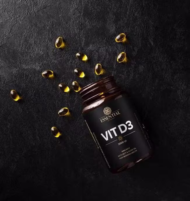 A imagem mostra o frasco deitado em fundo preto, sem a tampa e com cápsulas espalhadas ao redor.