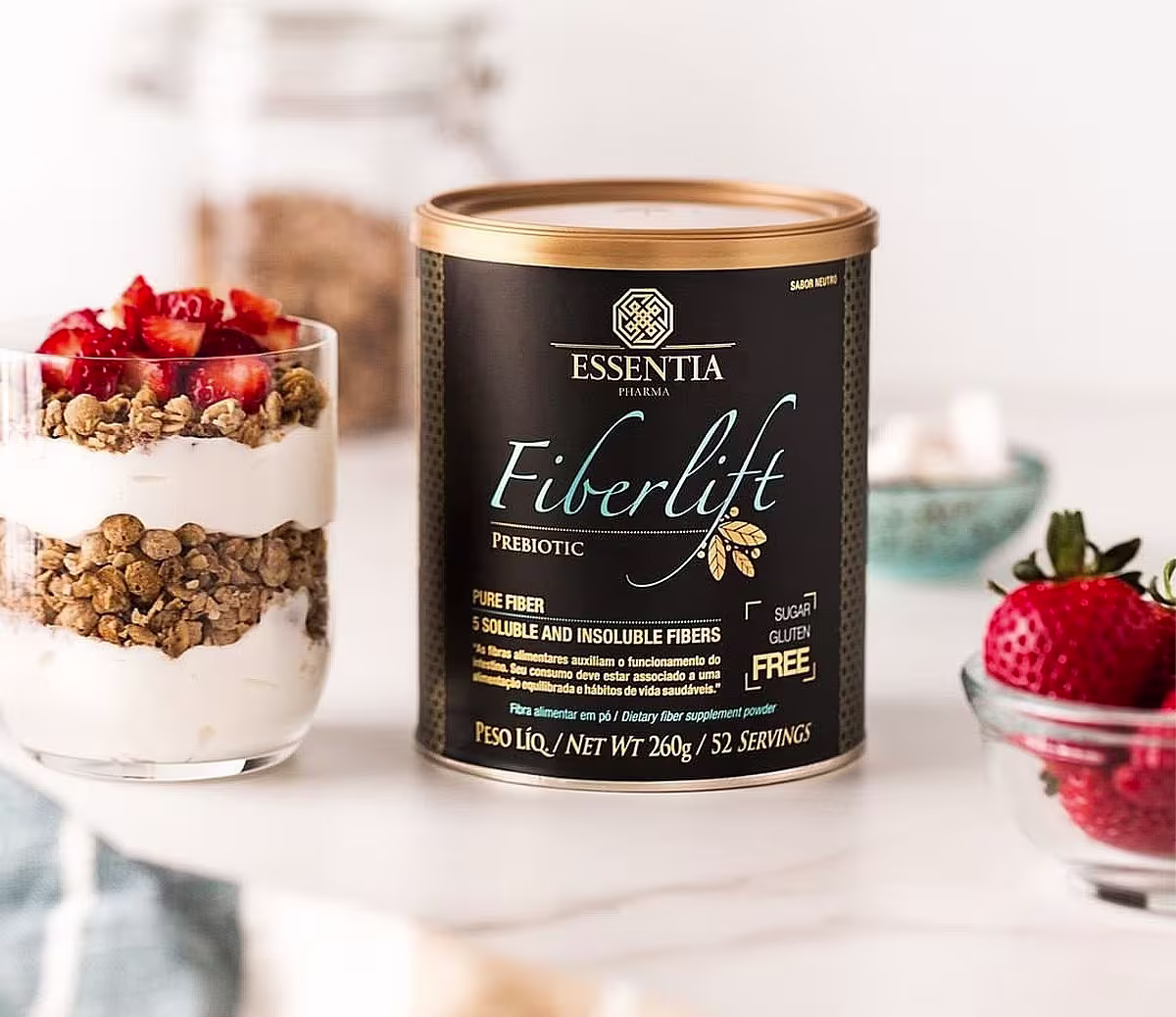 A imagem mostra a lata de suplemento ao lado de um copo com iogurte e morango.
