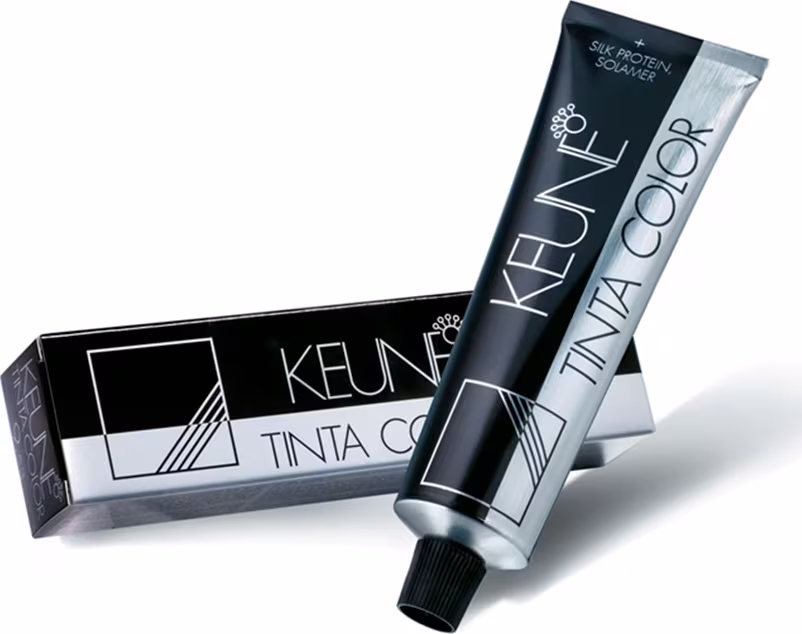 Produto de coloração capilar da marca Keune. Tubo plástico preto com rótulo branco contendo o nome "Keune" e "Tinta Color". Caixa retangular preta com detalhes geométricos brancos e o texto "Tinta Color" impresso.