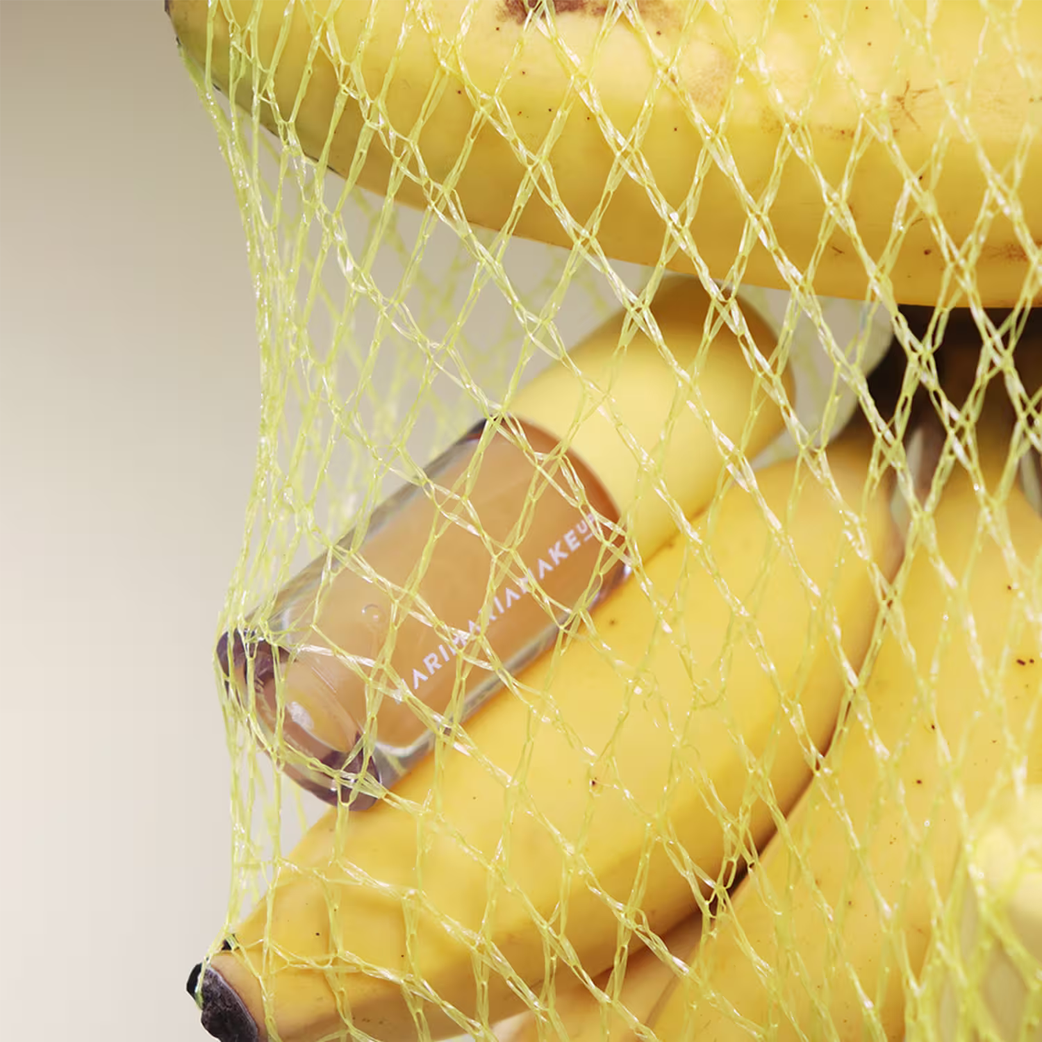 Imagem de uma rede de compras repleta de bananas com o lip juice Mari Maria