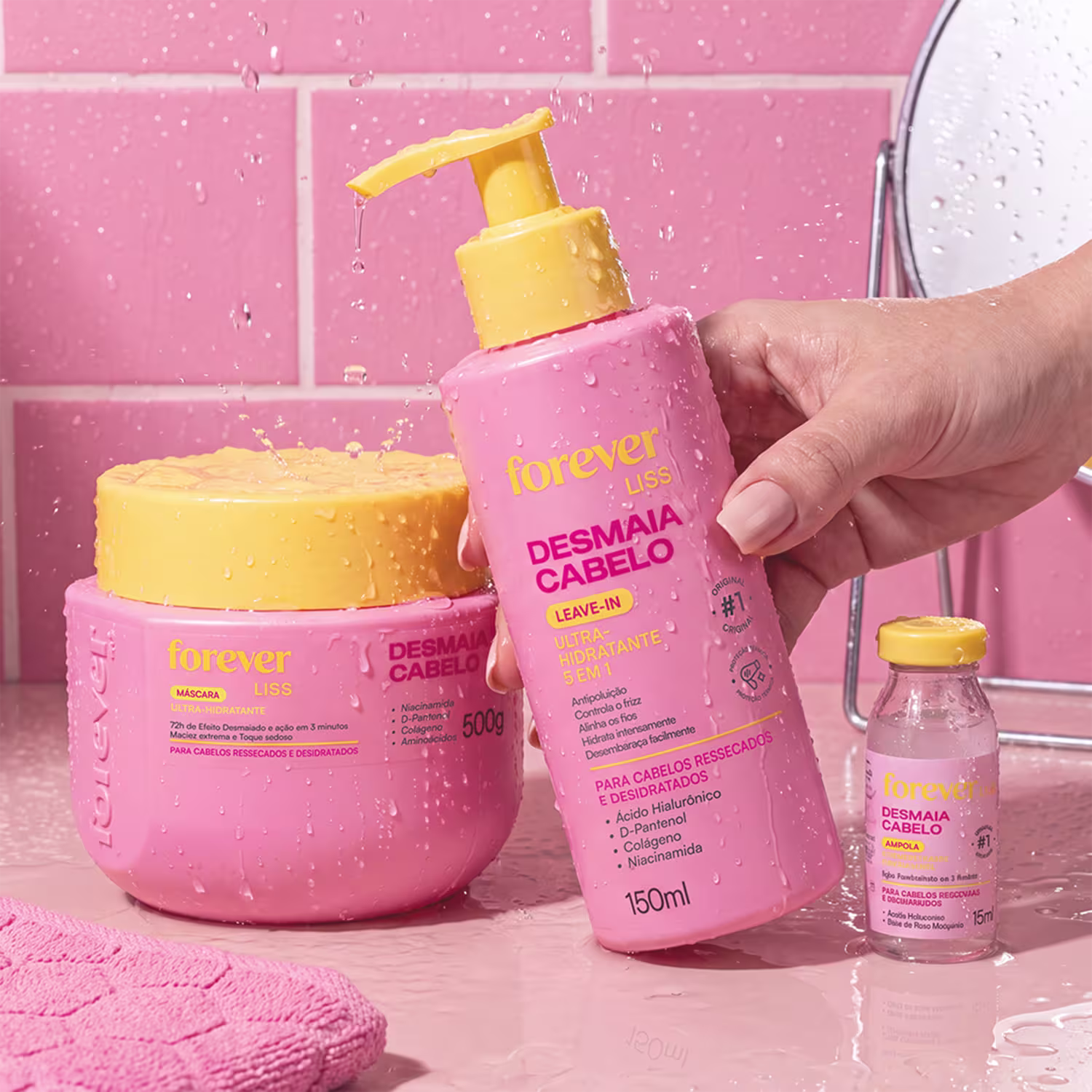 Produtos de beleza da marca Forever Liss, incluindo um frasco de leave-in hidratante, um pote de máscara hidratante e uma ampola de tratamento capilar, todos em cores rosa e amarela.
