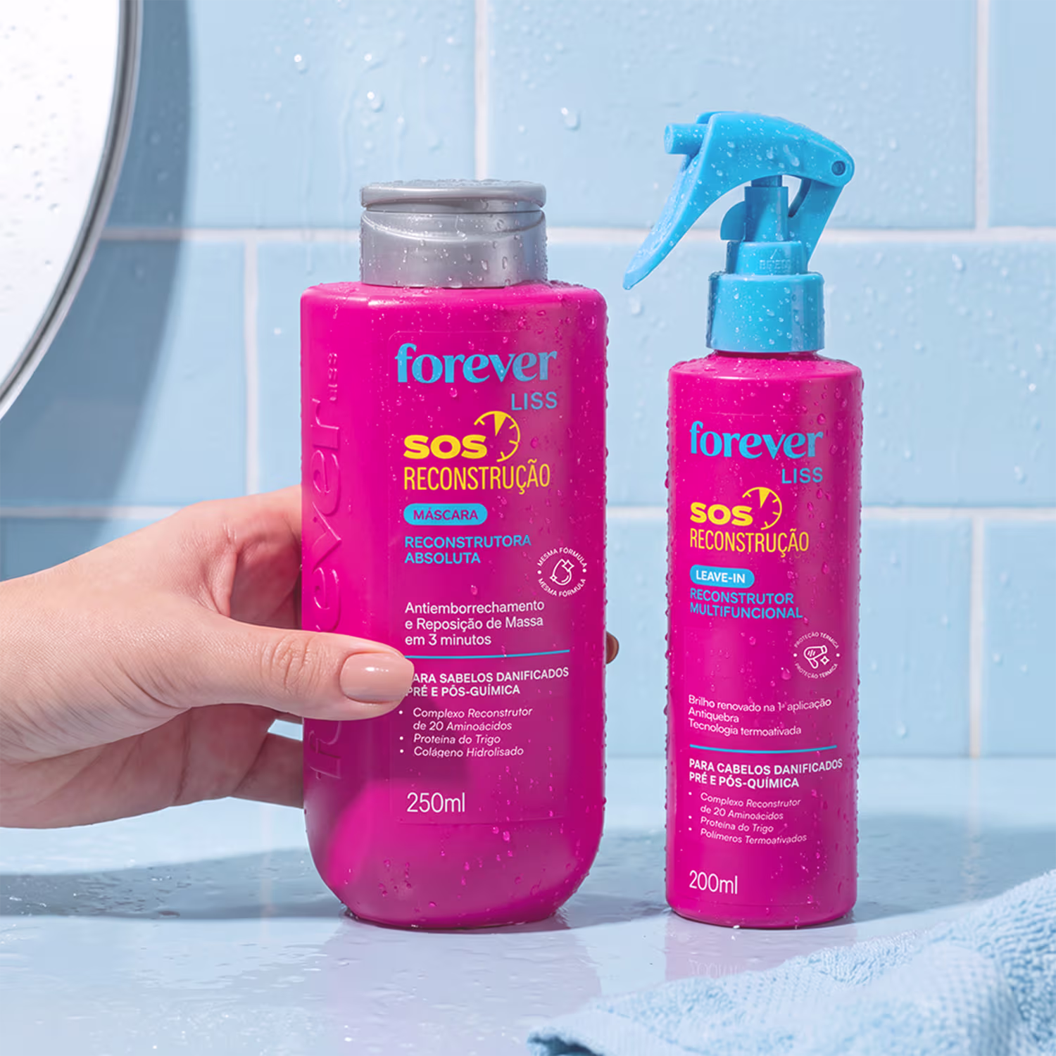 Dois produtos da linha Forever Liss: uma máscara reconstrutora de cabelos em embalagem rosa e um leave-in reconstrutor em embalagem rosa e azul, ambos com rótulos indicando a função "SOS Reconstrução".
