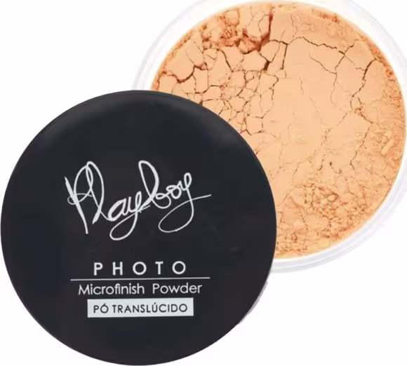 Pó compacto translúcido da linha Photo da Playboy, em embalagem preta com logotipo da marca. O produto apresenta textura granulada e coloração alaranjada.