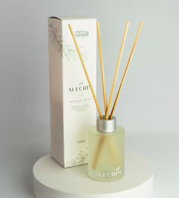 Frasco de difusor de aromas da marca Empório Essenza Serra Gaúcha, com embalagem branca e detalhes em amarelo, contendo líquido incolor e varetas de madeira para dispersão do aroma.