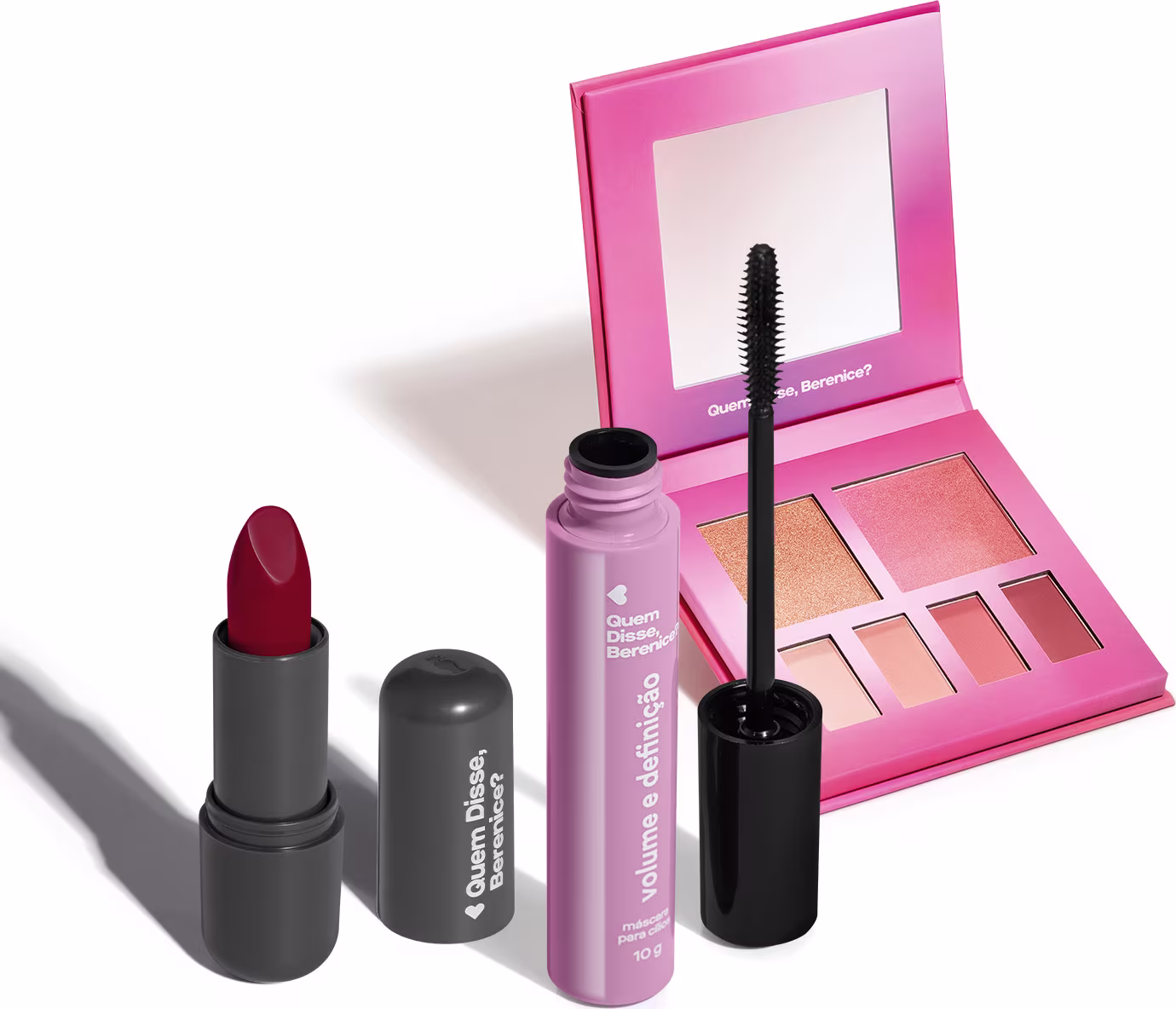 Conjunto de produtos de beleza da marca Quem Disse, Berenice? incluindo um batom vermelho, um rímel preto e uma paleta de maquiagem rosa com espelho.