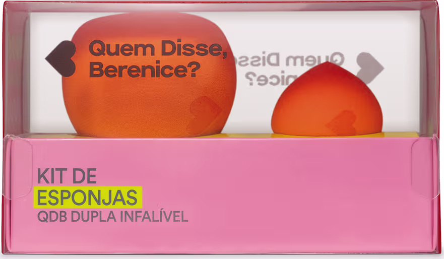 O kit é composto por duas esponjas de diferentes formatos, uma redonda e outra em formato de gota, ambas na cor laranja. A embalagem é uma caixa retangular rosa, com o texto "Kit de Esponjas QDB Dupla Infalível" impresso na parte frontal.