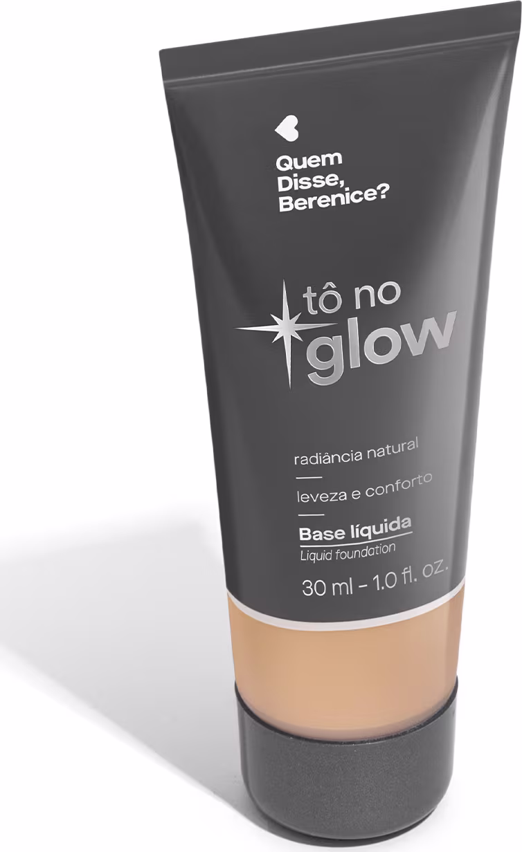 O produto apresentado é uma base líquida da marca Tô no Glow, com embalagem em tubo plástico de cor cinza escura. O rótulo exibe o nome da marca e o texto "Radiância natural, leveza e conforto" em letras brancas.