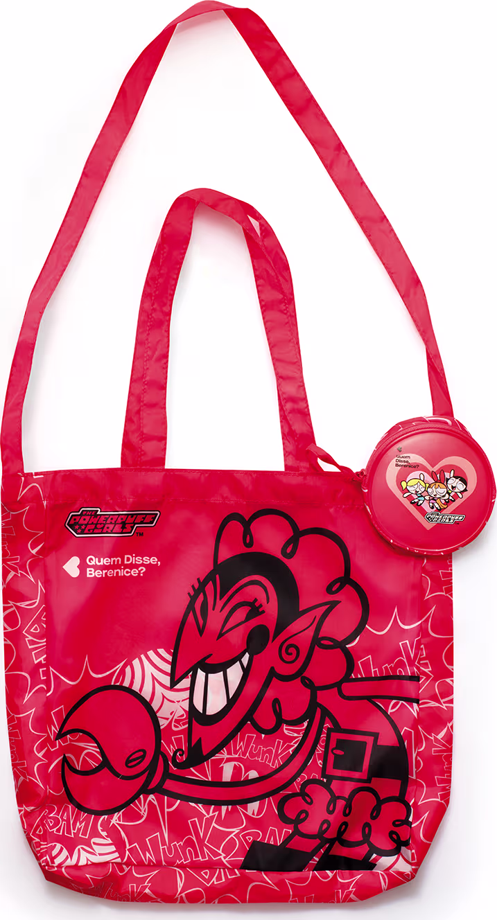 Bolsa vermelha com estampa das Meninas Superpoderosas, contendo um acessório redondo com o mesmo design. A bolsa possui alças longas e um texto em destaque na parte frontal.