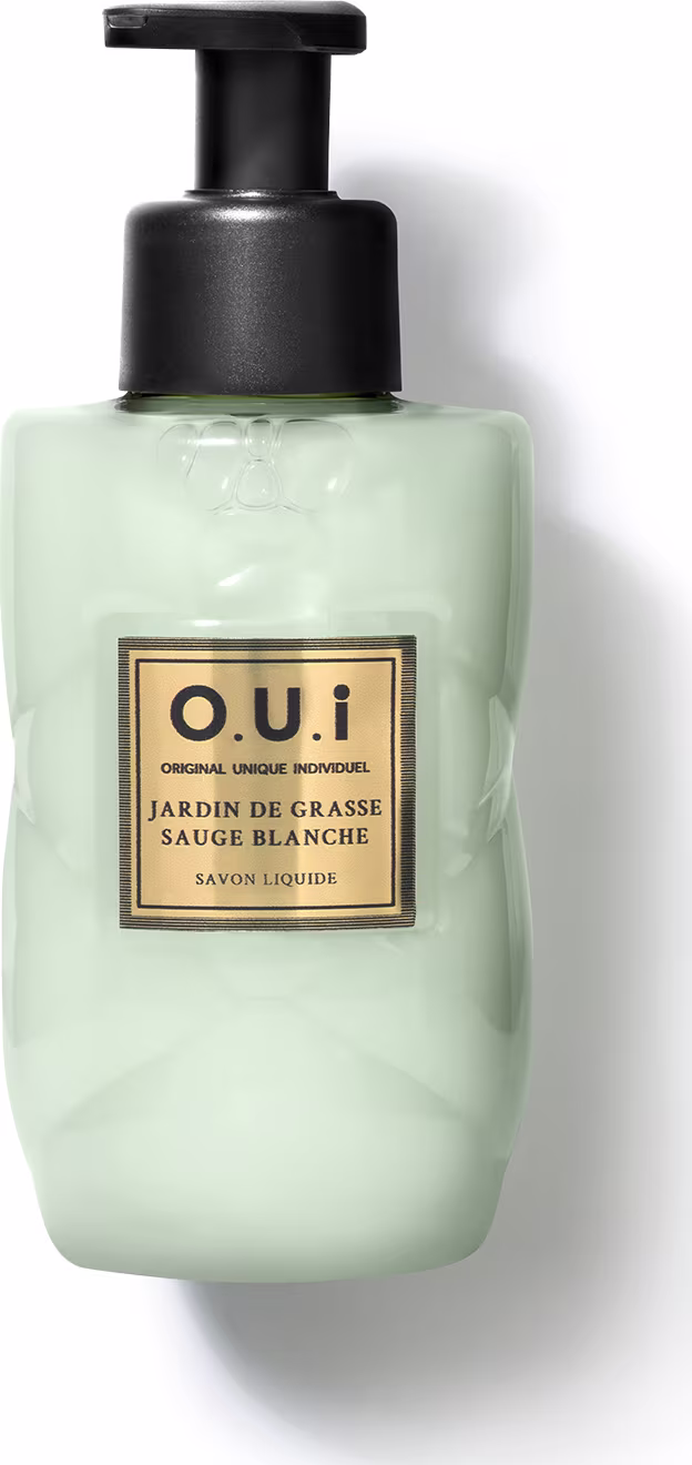 Frasco tipo pump de sabonete líquido da marca O.U.i. com rótulo em fundo verde-claro e detalhes dourados, contendo a descrição "Jardin de Grasse Sauge Blanche" (Jardim de Grama Branca).