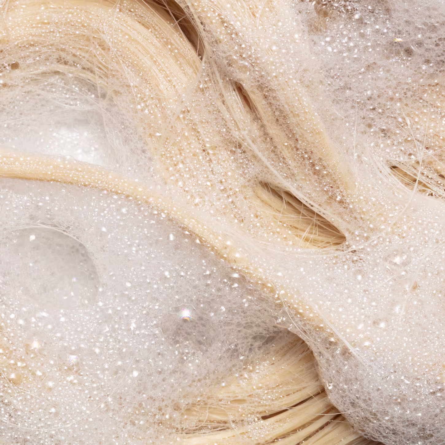 Shampoo da linha Blond Revolution da marca TRUSS. Imagens de cabelos sendo limpos com o produto.