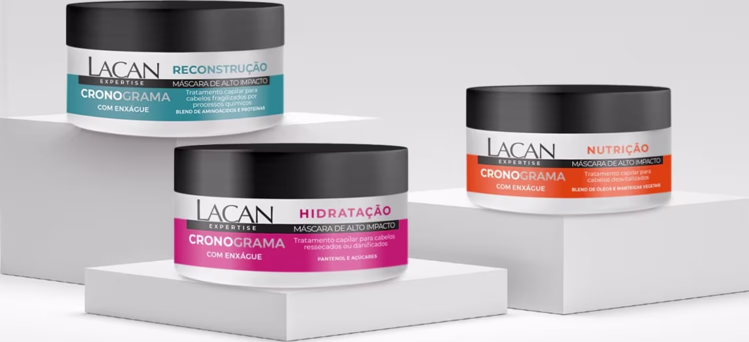 Três potes de máscaras capilares da marca Lacan, com embalagens em tons de branco, laranja e rosa, exibindo os nomes "Cronograma" e indicações de reconstrução, nutrição e hidratação.