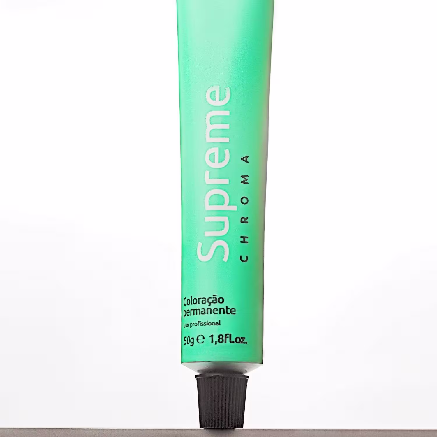 A imagem mostra o tubo plástico verde contendo coloração permanente para cabelo da marca Supreme. A tampa na parte inferior é preta.