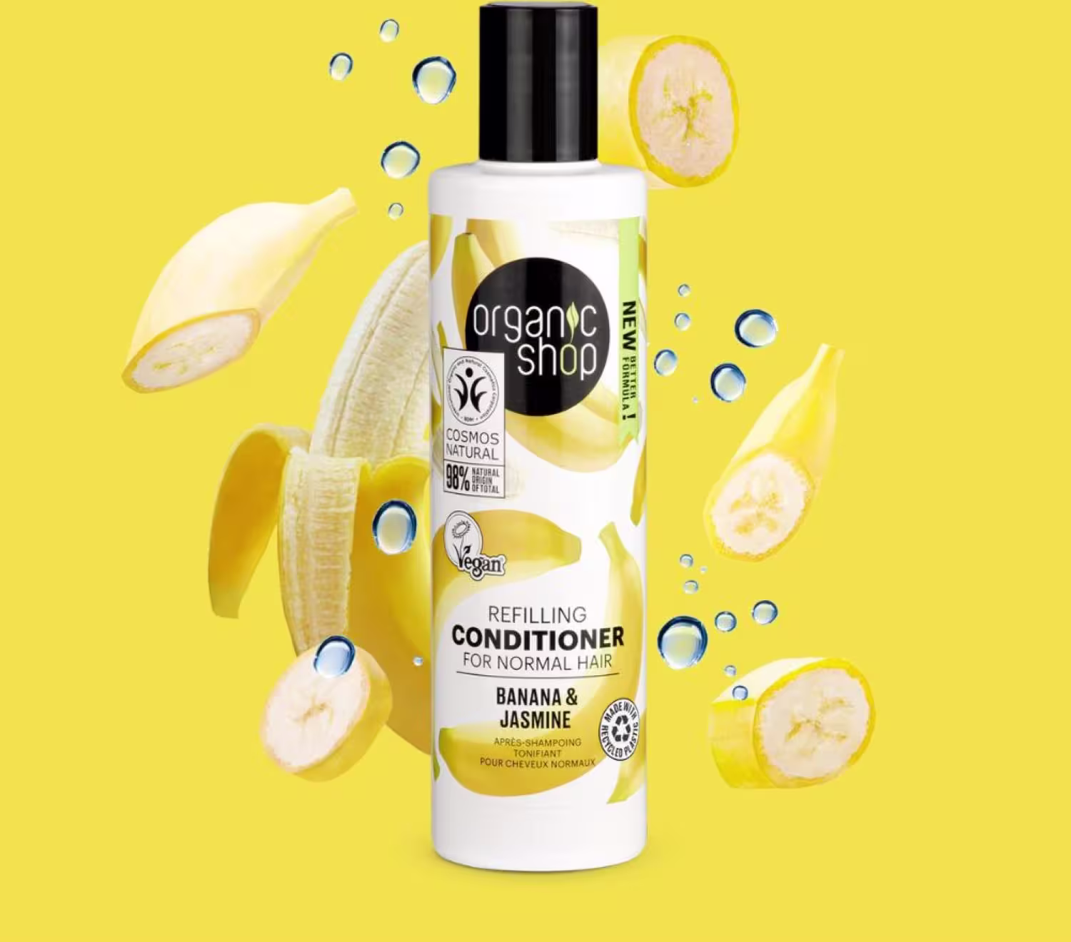 A imagem mostra o condicionador em um fundo amarelo. Ao redor da embalagem, há fatias de banana e gotas d'água espalhadas.
