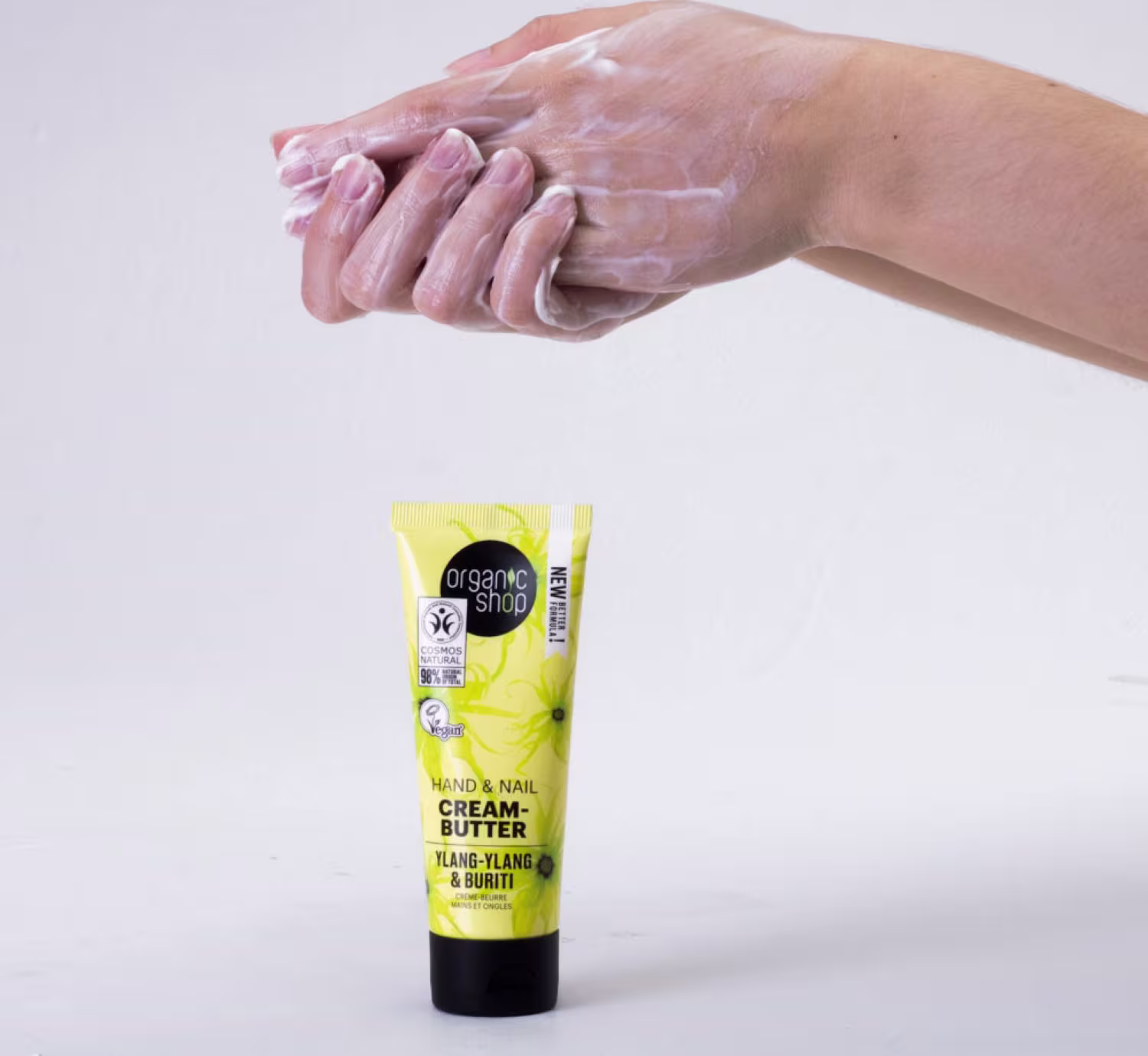 A imagem mostra o creme para mãos e na parte de cima duas mãos aplicando o produto.