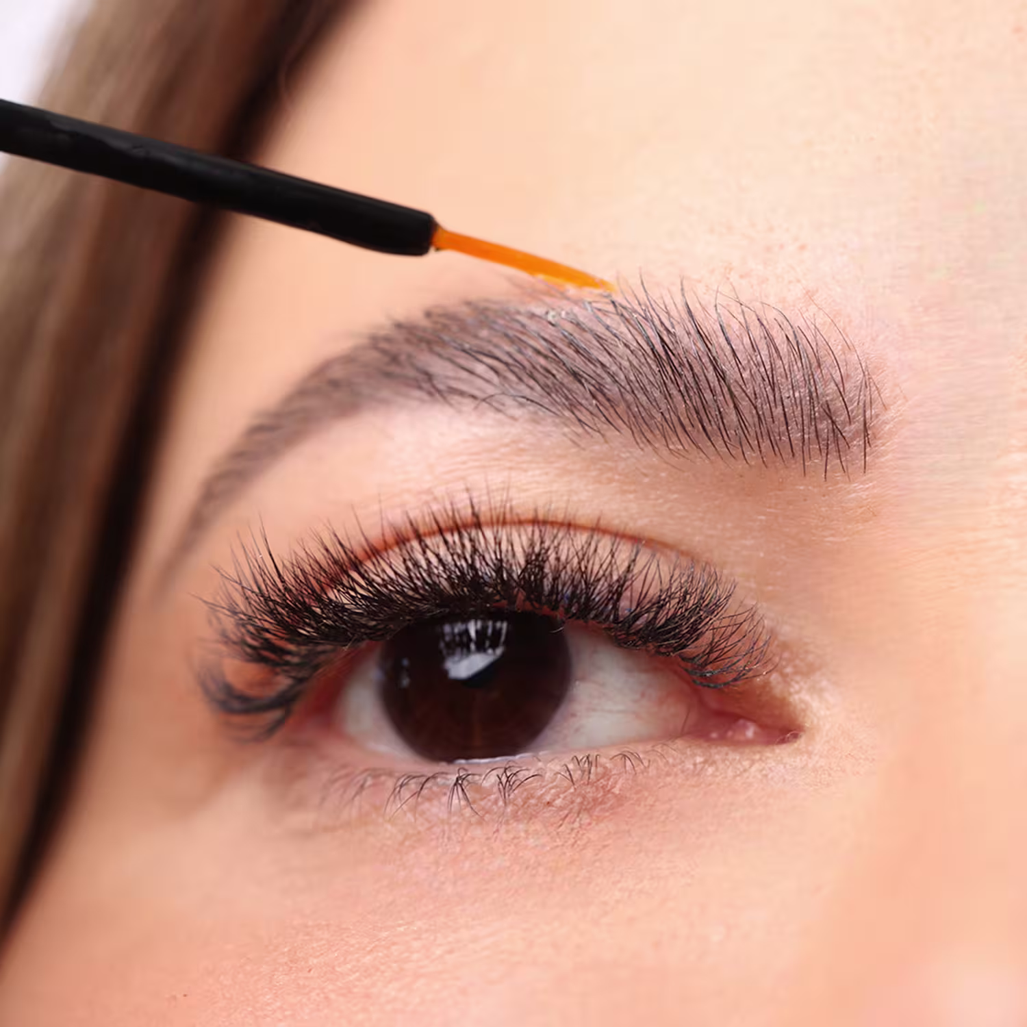 Os cílios e sobrancelhas da modelo aparecem longos e volumosos, indicando que o produto é eficaz em realçar e embelezar os olhos.