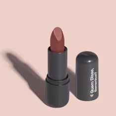 O produto apresentado na imagem é um batom da marca Quem Disse, Berenice?. O batom possui uma embalagem preta com o logotipo da marca em destaque. A cor do batom é um tom de marrom avermelhado.