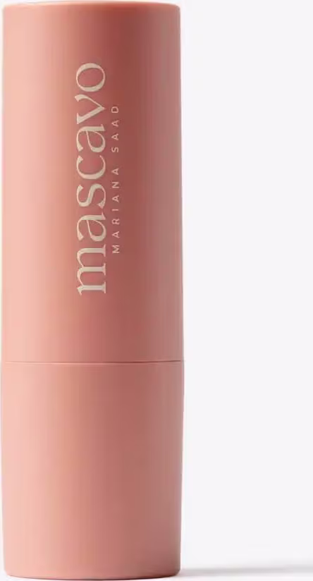 O produto apresentado é o blush Flush Stick Mascavo, em uma embalagem cilíndrica de cor rosa clara. O rótulo do produto exibe o nome "Mascavo" em letras brancas.