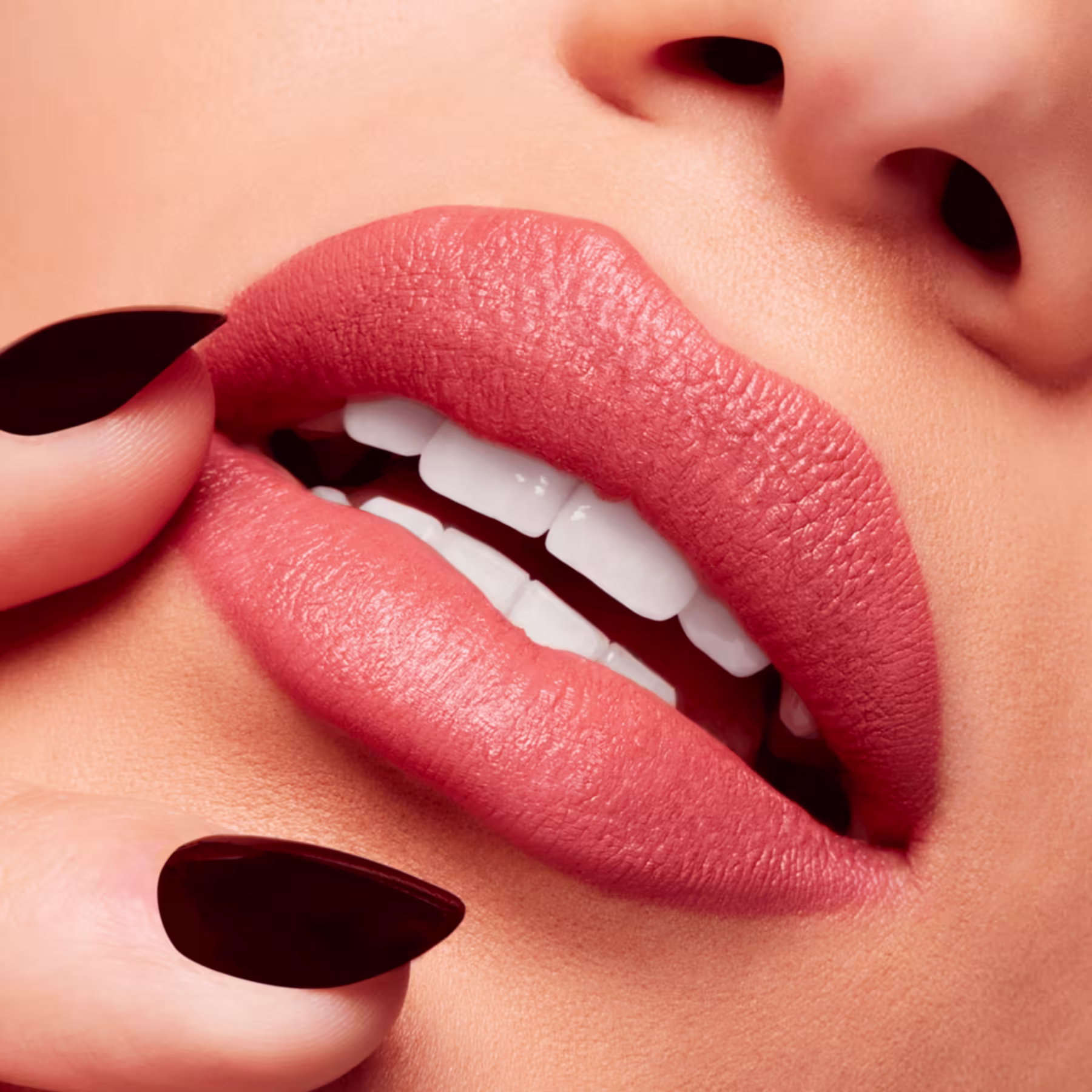 A imagem mostra a boca de uma mulher usando o batom.