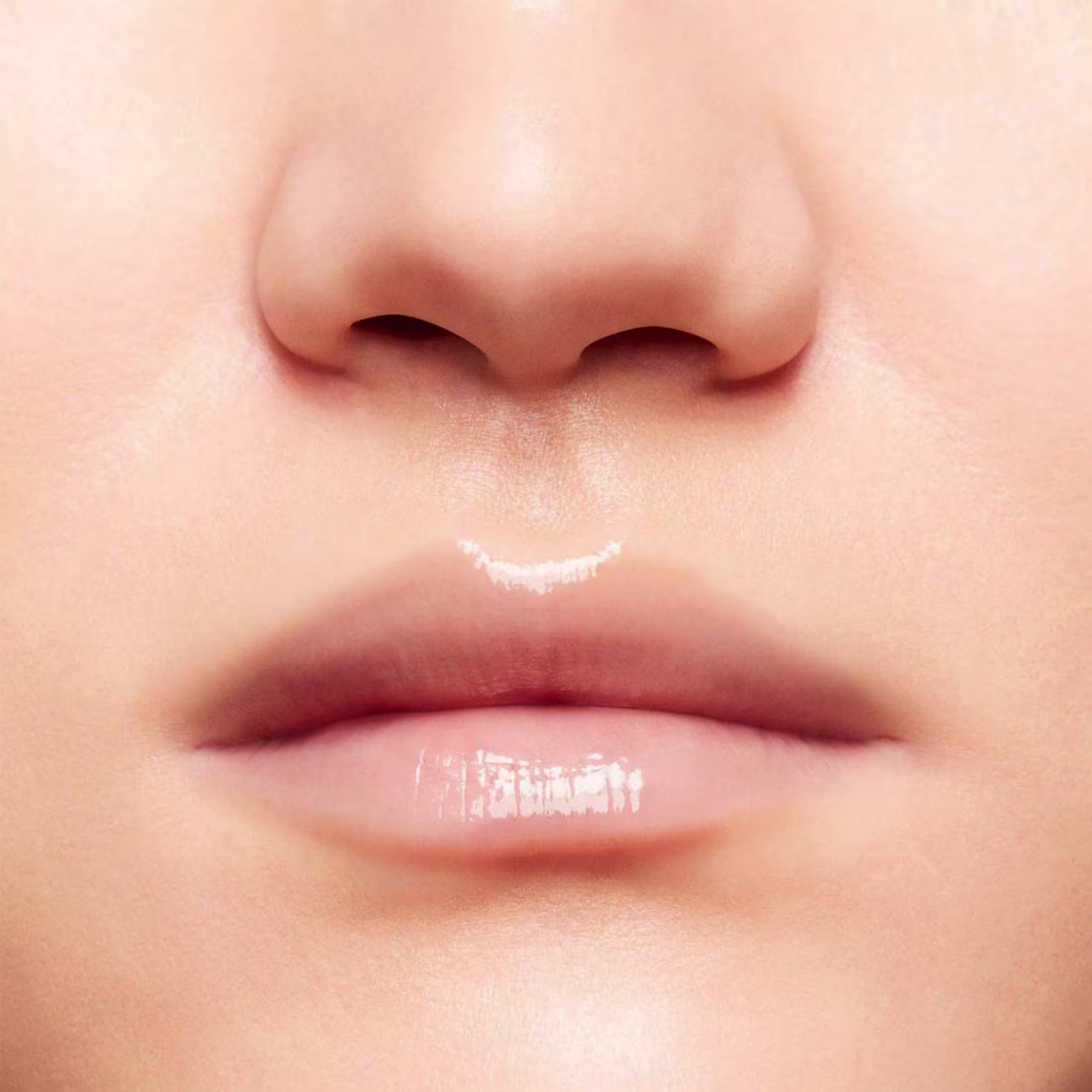 A imagem mostra a boca de uma mulher usando o balm.