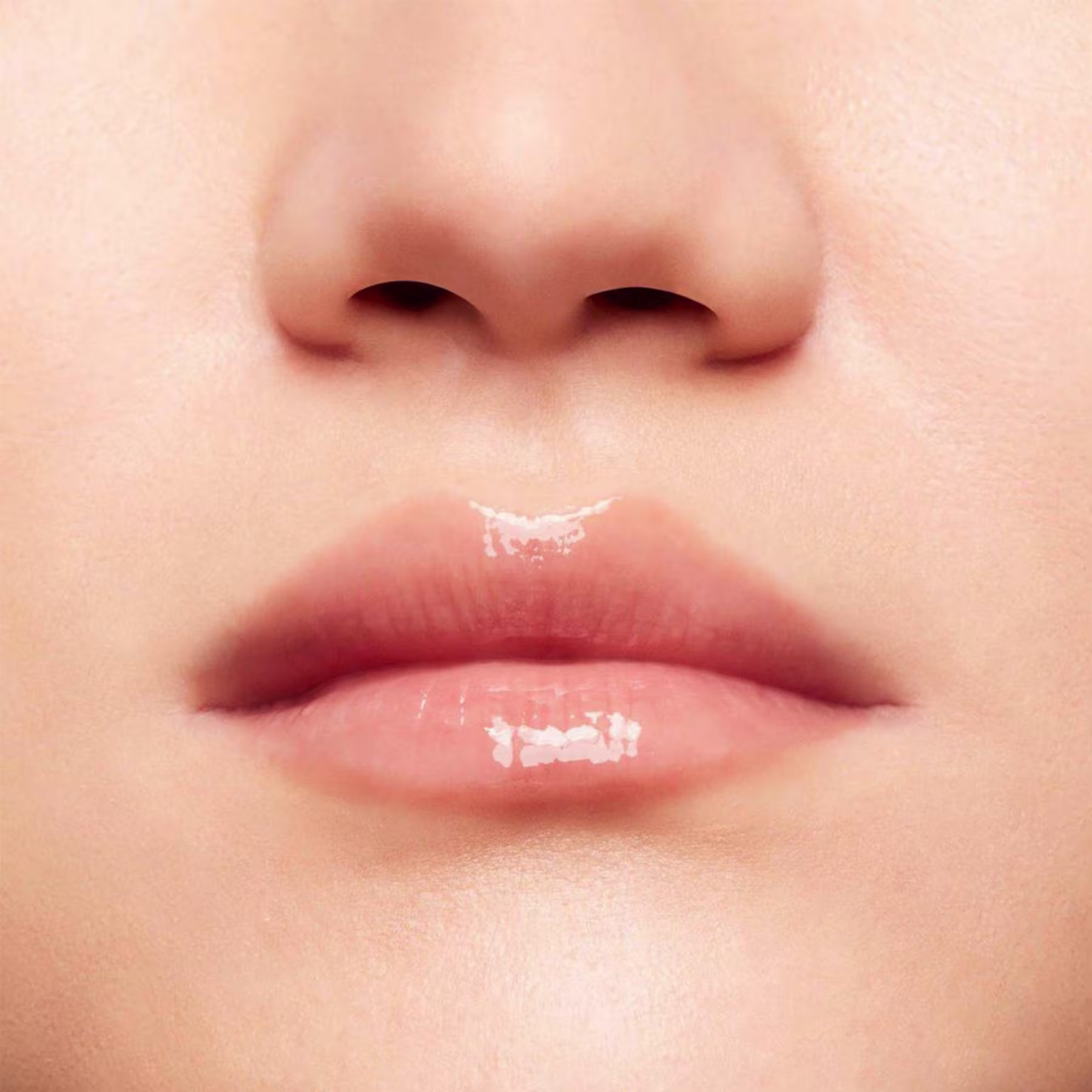 A imagem mostra a boca de uma mulher usando o balm.