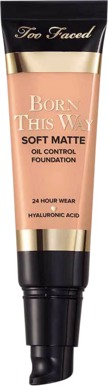 A imagem mostra uma embalagem pequena, sem a tampa, tipo bisnaga, de base líquida, cor muito clara. A embalagem tem detalhes bege e preto, com letra pretas e dourada.