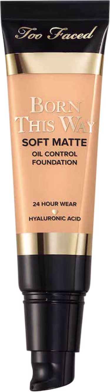 A imagem mostra uma embalagem pequena, sem a tampa, tipo bisnaga, de base líquida, cor muito clara. A embalagem tem detalhes bege e preto, com letra pretas e dourada.