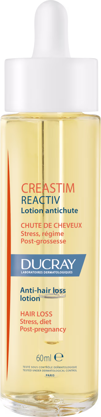 A imagem mostra um frasco transparente contendo um líquido amarelo claro. É o "Creastim Reactiv", da marca Ducray. Trata-se de uma loção antiqueda de cabelo. O frasco tem um aplicador em formato de conta-gotas na parte superior e 60ml de produto.