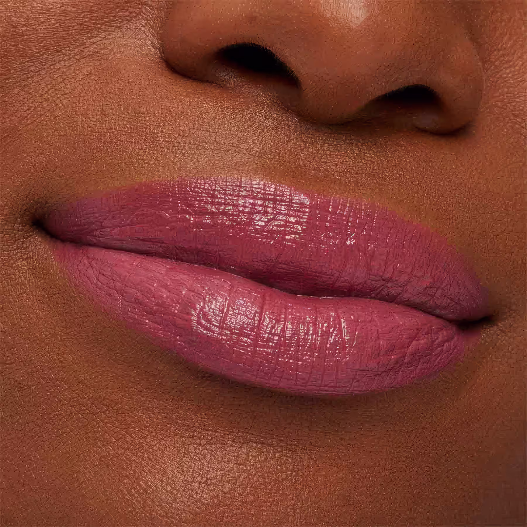 A imagem mostra a boca de uma mulher usando o batom.