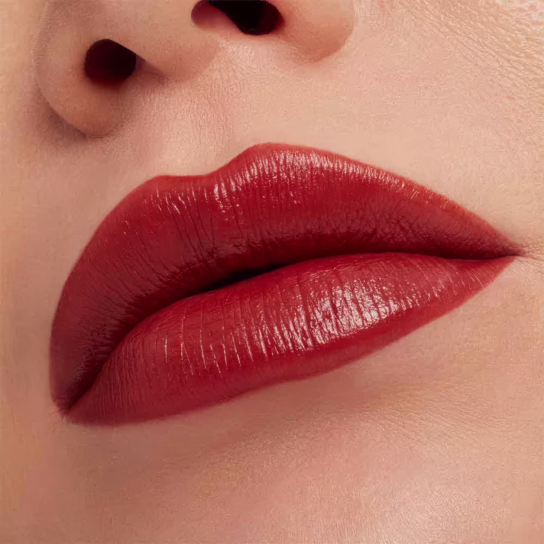 A imagem mostra a boca de uma mulher usando o batom.