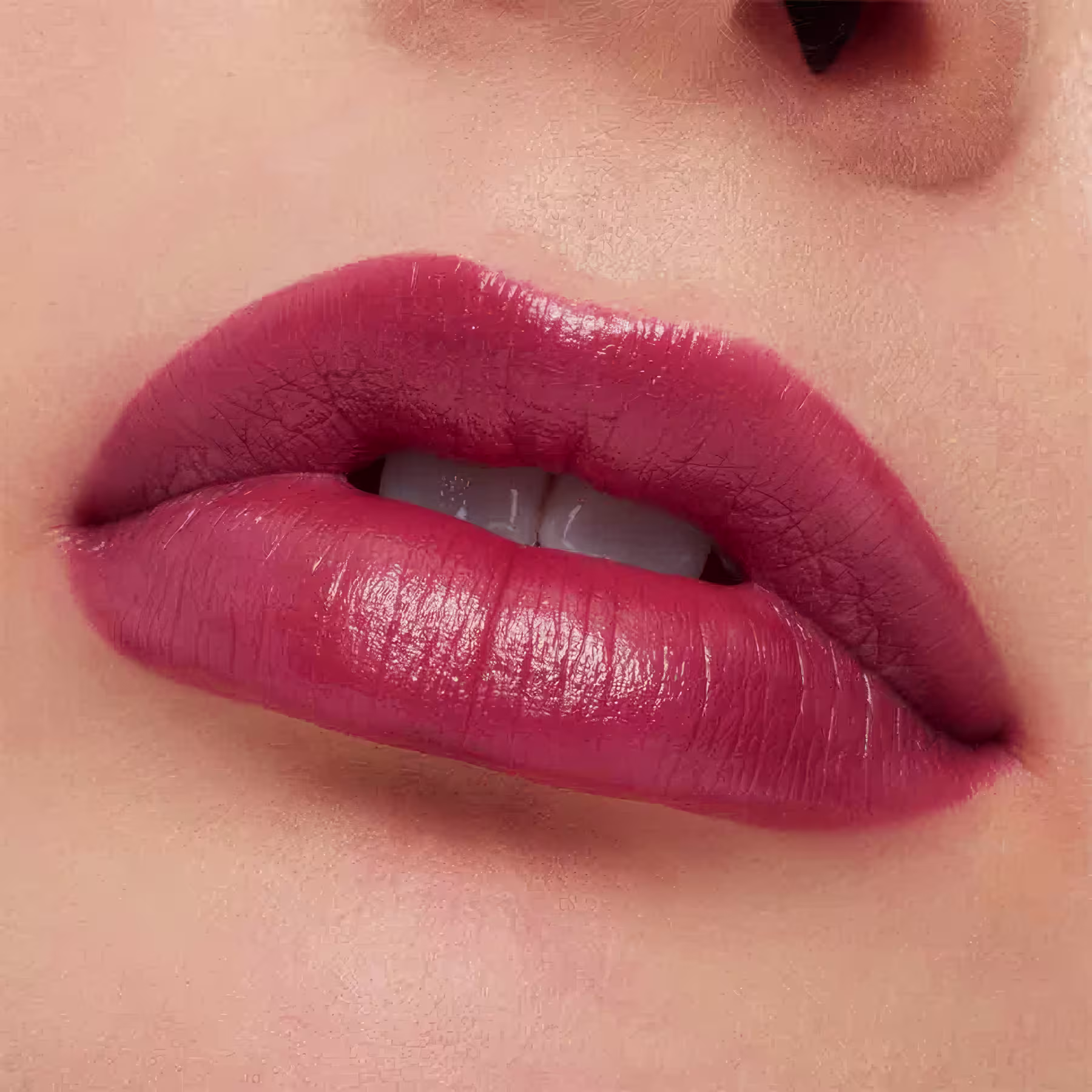 A imagem mostra a boca de uma mulher usando o batom.