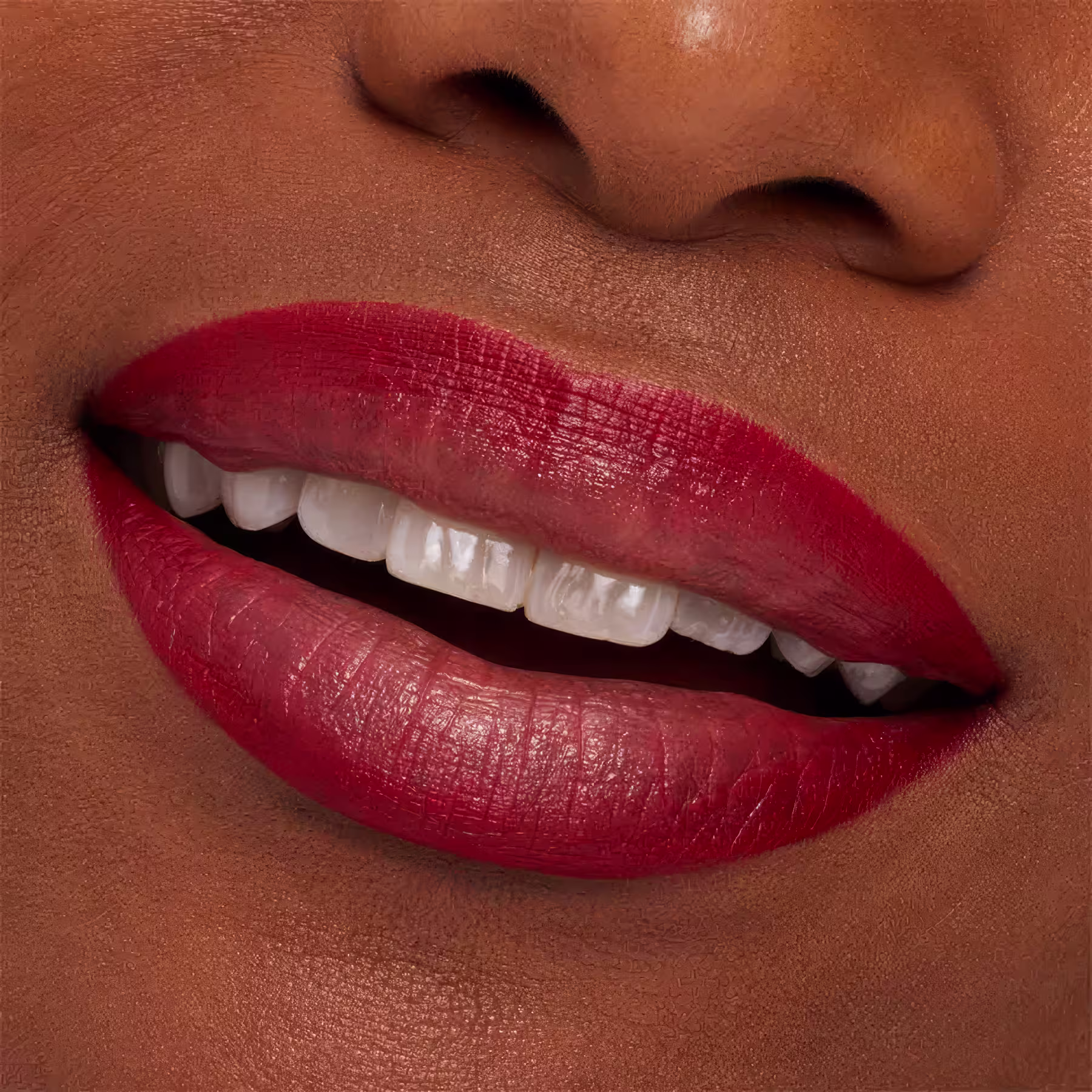 A imagem mostra a boca de uma mulher usando o lápis de boca.