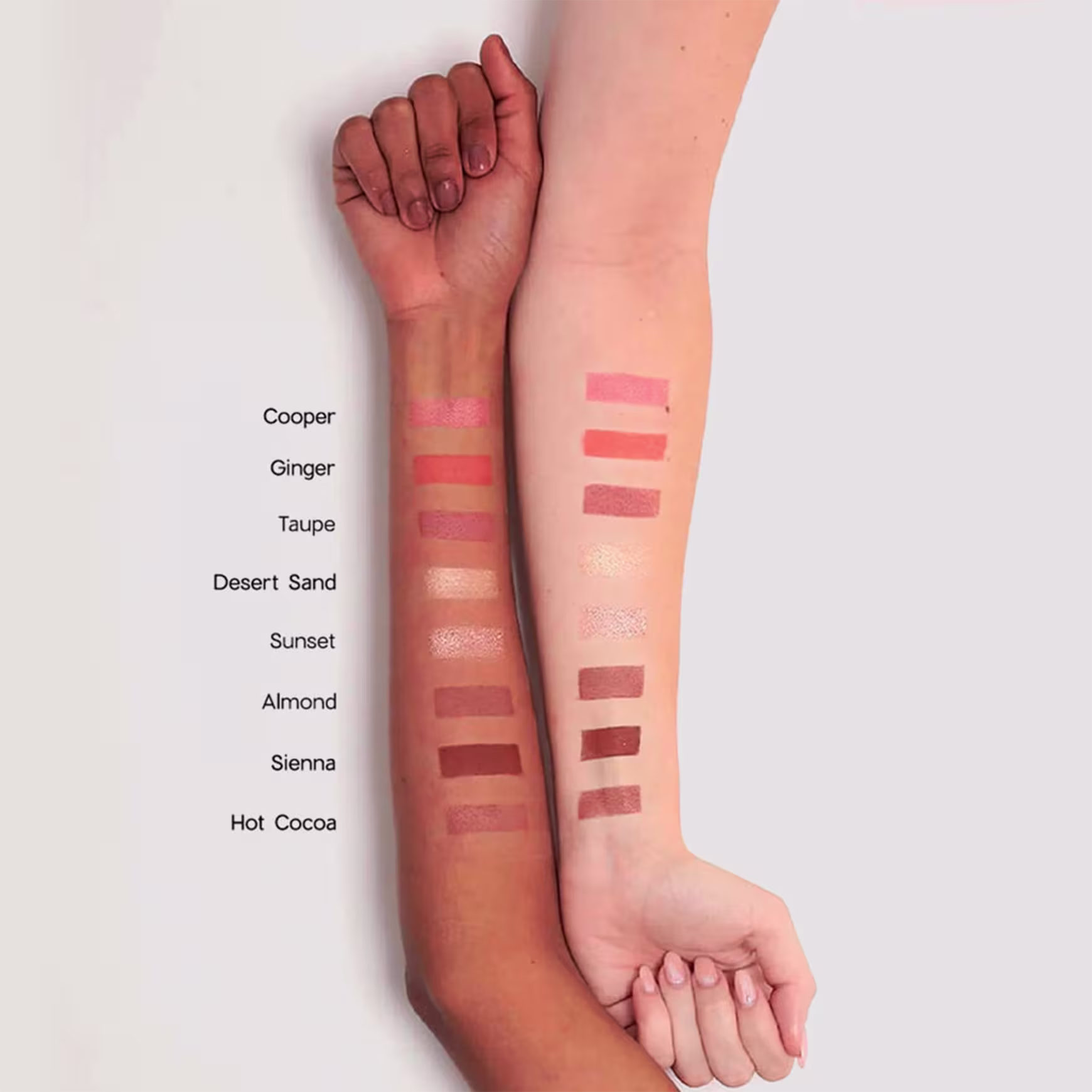 Esta imagem mostra uma variedade de tons apresentados em listras aplicadas no antebraço de uma pessoa negra e de uma pessoa branca. Exemplificando como cada tom se comporta em cada tom de pele.