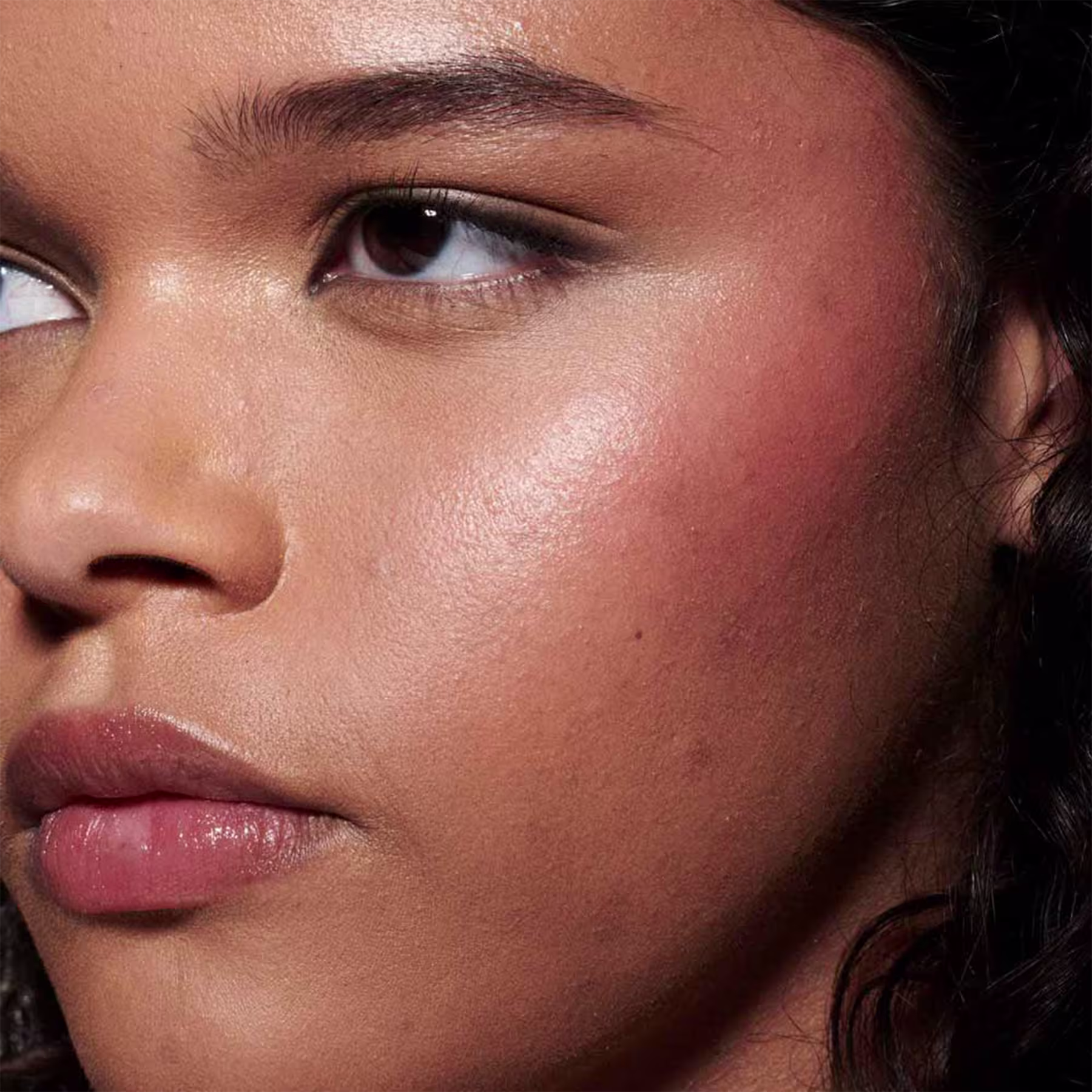 A imagem mostra uma modelo morena e o efeito de cor do Blush Líquido M·A·C Strobe Good Vibes