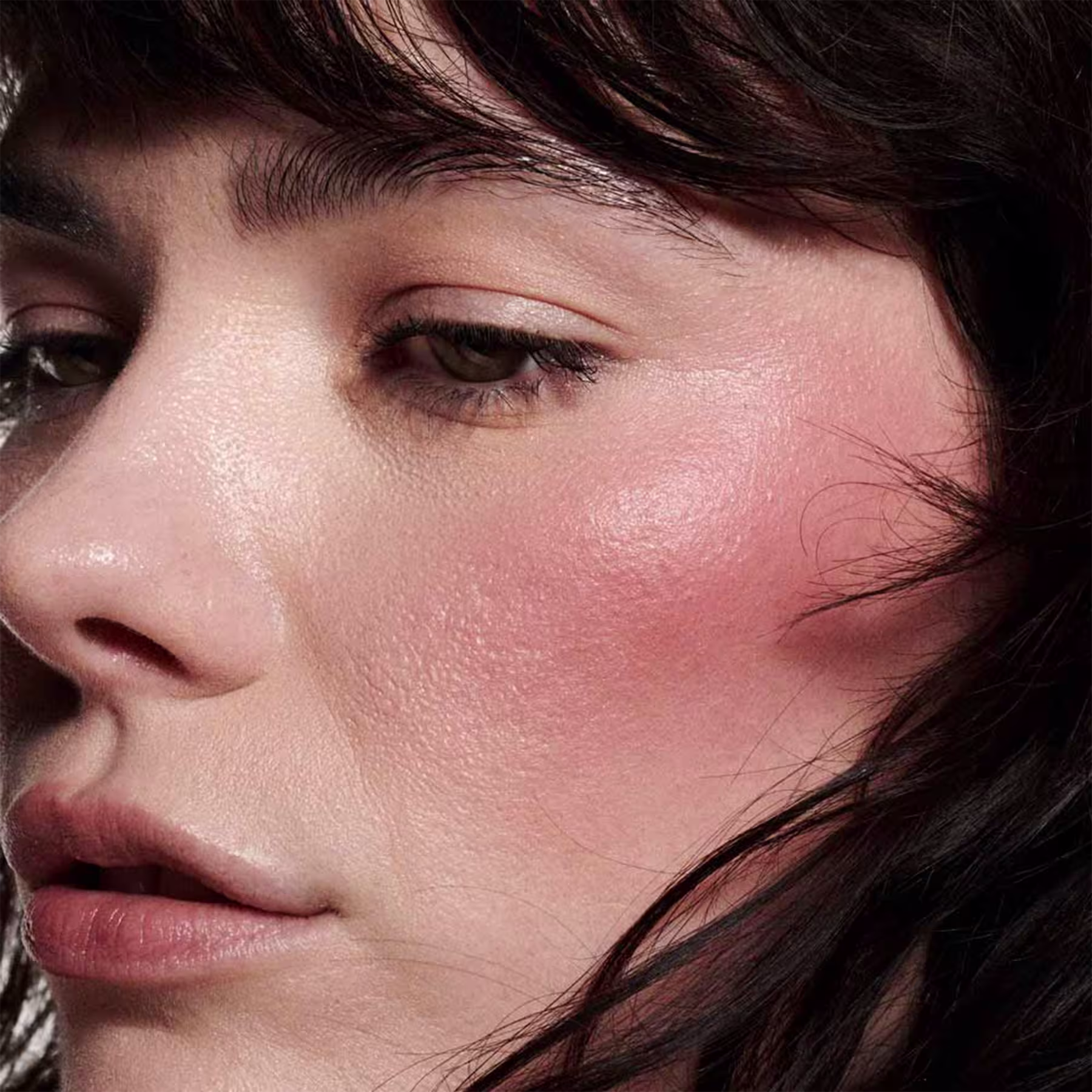 A imagem mostra uma modelo com a pele clara e o efeito de cor do Blush Líquido M·A·C Strobe Plummy Bare