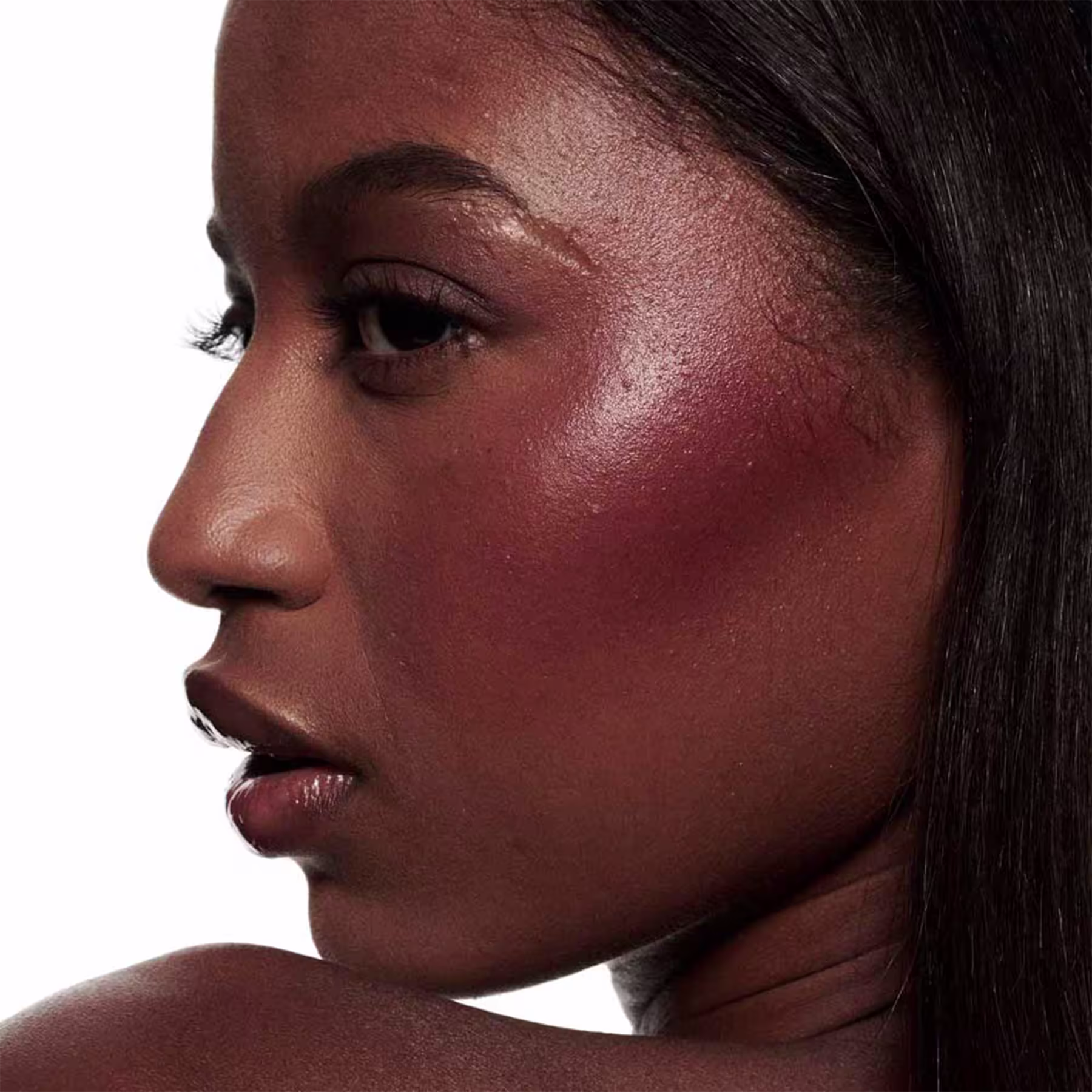 A imagem mostra uma modelo com a pele negra e o efeito de cor do Blush Líquido M·A·C Strobe Plummy Bare