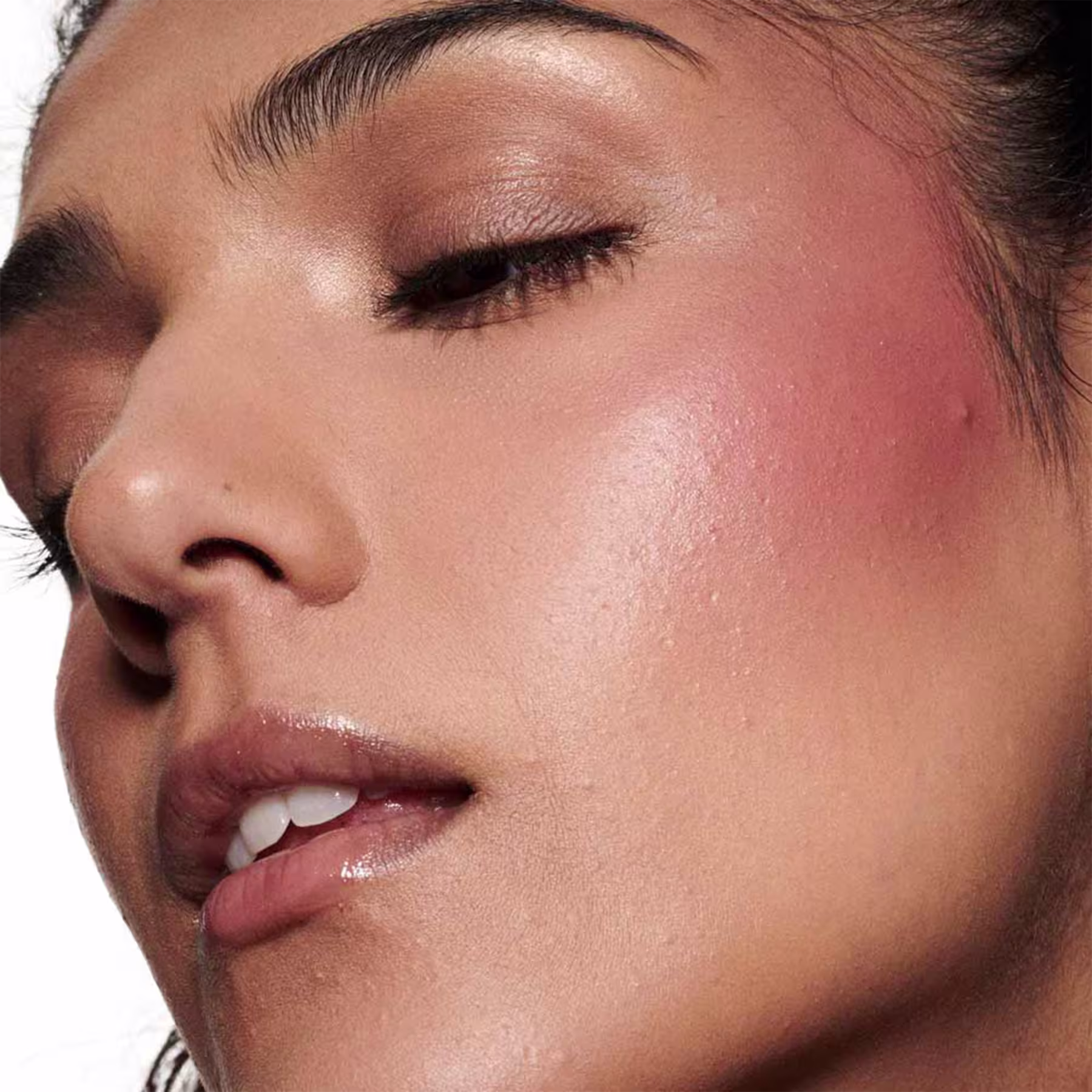 A imagem mostra uma modelo morena e o efeito de cor do Blush Líquido M·A·C Strobe Plummy Bare