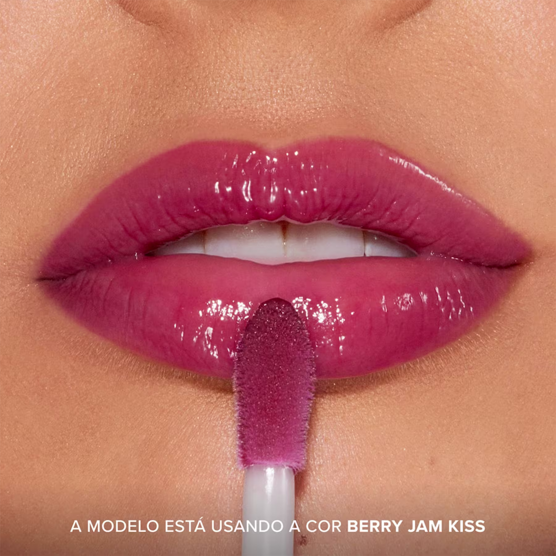 A imagem mostra o resultado do uso do Lip Treatment Too Faced Pillow Balm, com foco nos lábios. Frase: A modelo está usando a cor Berry Jam Kiss