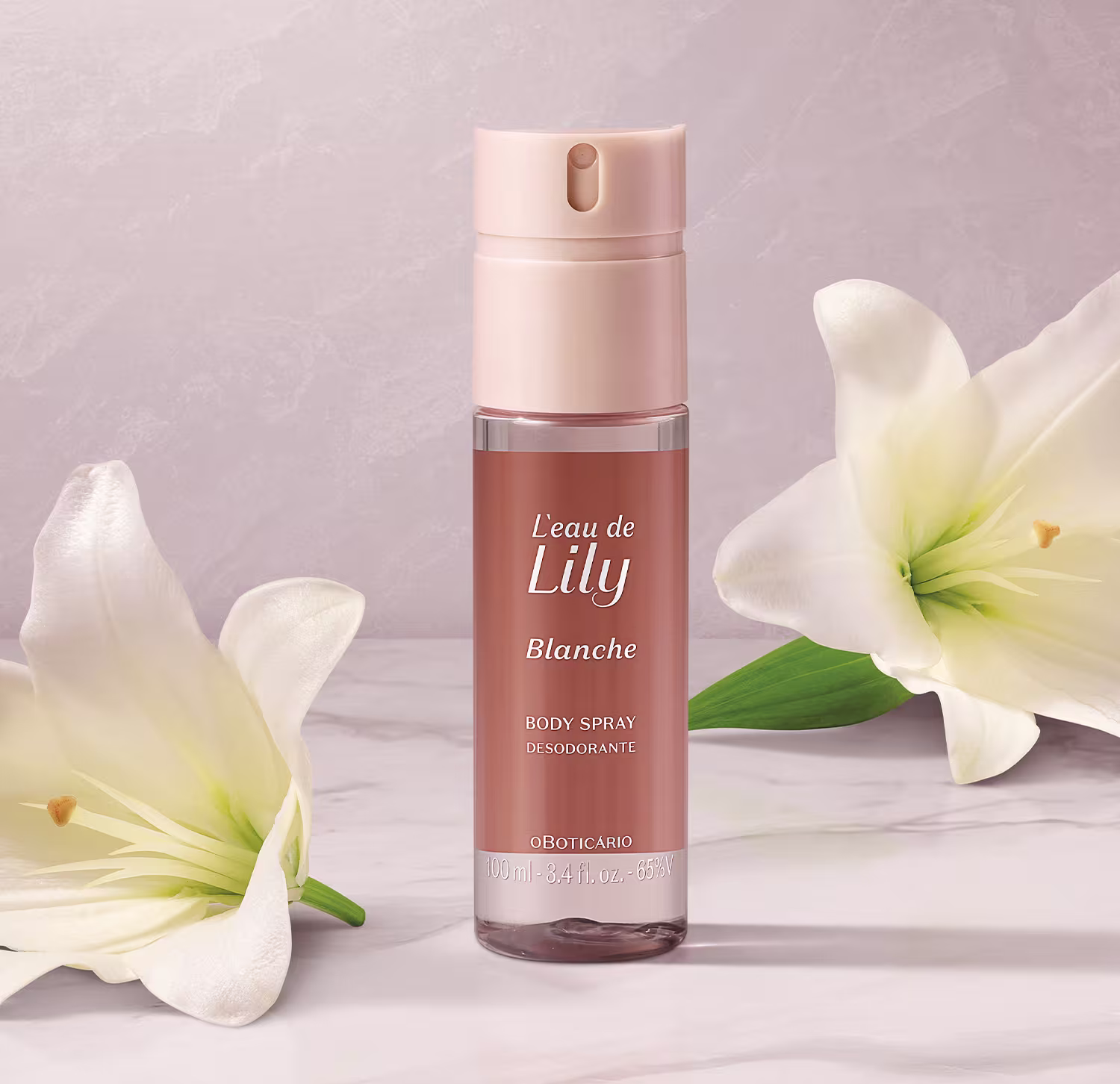 O frasco é de cor rosa claro, com um rótulo que exibe o nome da fragrância em destaque. O produto é apresentado em um recipiente com um aplicador spray. Ao lado do frasco, há flores de lírio brancas, que parecem complementar a imagem do produto.