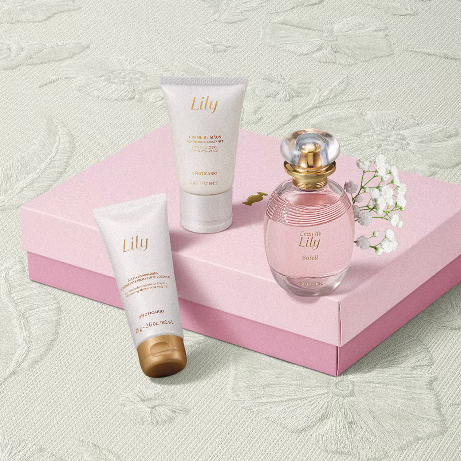 Os produtos estão dispostos sobre uma superfície rosa, com uma caixa rosa também visível, sugerindo que se trata de um conjunto ou kit de produtos da marca Lily.