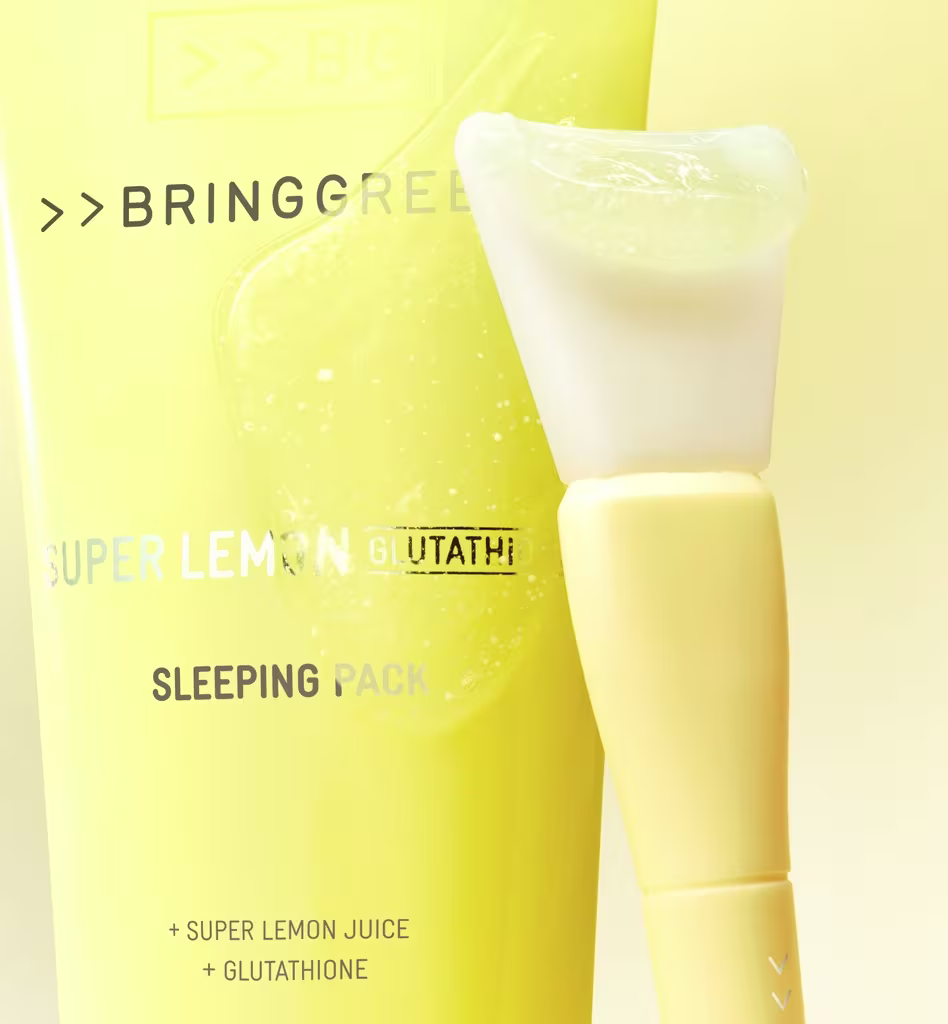 Embalagem amarela da marca Bringgreen contendo um produto de tratamento de pele chamado "Super Lemon Sleeping Pack", com espátula de aplicação ao lado